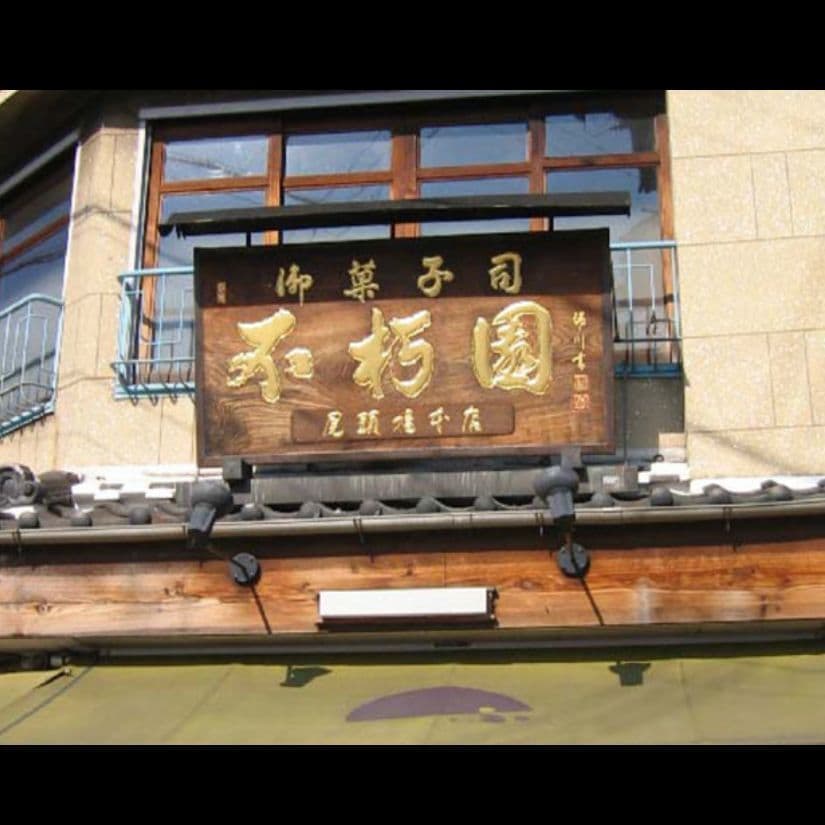 店の入り口の上に銅の屋根の着いた和風看板で文字は金箔を使っている