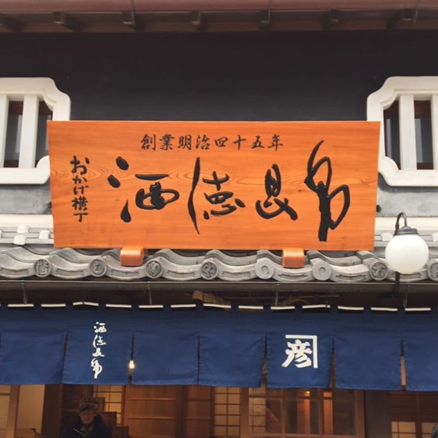 和風建築にふさわしい木の看板で文字を彫って黒塗装の昆布店の看板