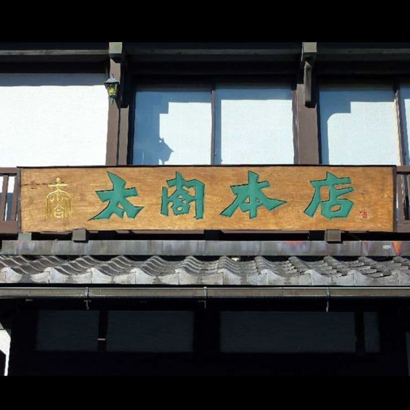 しゃぶしゃぶ店の入口の上の木の和風なイメージの彫刻看板